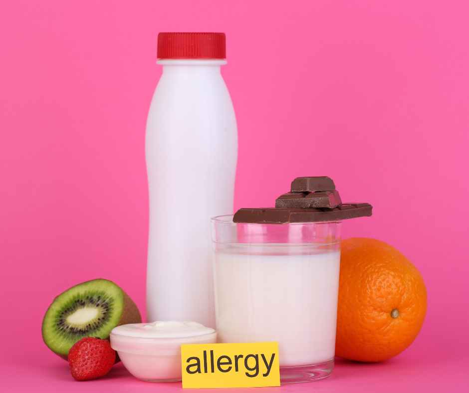 Parent feeding their baby a small spoonful of peanut butter in a highchair to introduce allergenic foods safely.