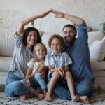 Parents and kids cooking together in a bright kitchen as part of their family wellness plan