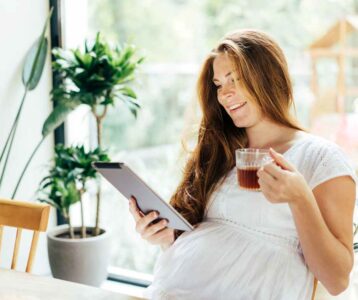 Pregnant woman sipping ginger tea at home to ease nausea—illustrating natural remedies for pregnancy discomforts