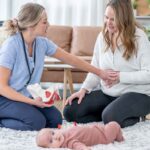 A Postpartum Body Changes, mom gently touching her belly while holding her newborn, reflecting on the changes her body has gone through.