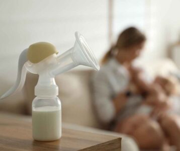 Mother choosing between breastfeeding and formula bottle – Breastfeeding vs. Formula comparison