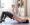 A mom sitting on a yoga mat practicing gentle pelvic floor exercises at home.