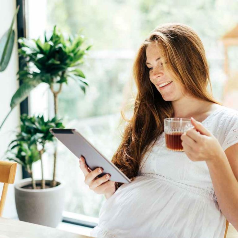 Pregnant woman sipping ginger tea at home to ease nausea—illustrating natural remedies for pregnancy discomforts