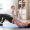 A mom sitting on a yoga mat practicing gentle pelvic floor exercises at home.