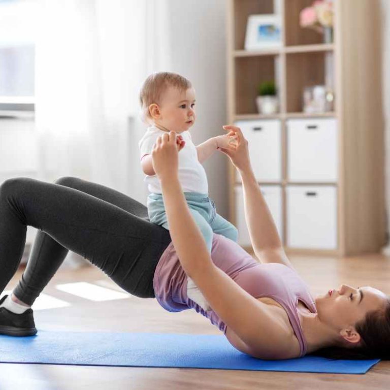 A mom sitting on a yoga mat practicing gentle pelvic floor exercises at home.
