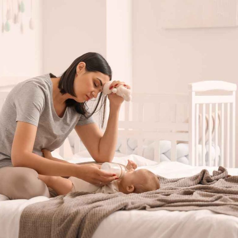 New mom gently looking at her postpartum body in the mirror, embracing changes after childbirth with confidence