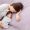 A tired mom resting on the couch with a cozy blanket and warm tea, recharging with a short rest. Sleep Strategies