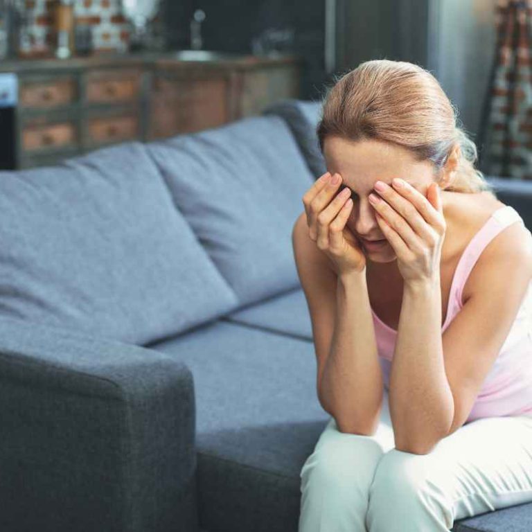 Mom Guilt sitting on the floor with her child hugging her, symbolizing both love and emotional overwhelm.